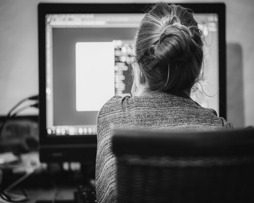 A person adjusting the brightness settings on an external computer monitor